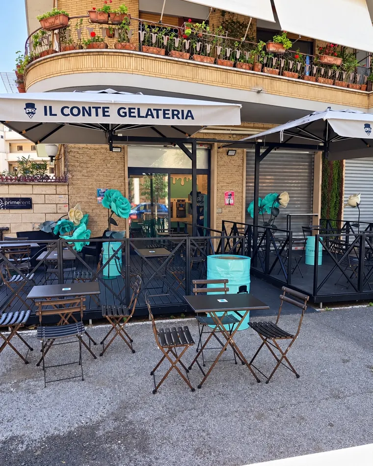 Il dehors di giorno, con l'ombrellone «Il Conte Gelateria» e le rose color Tiffany