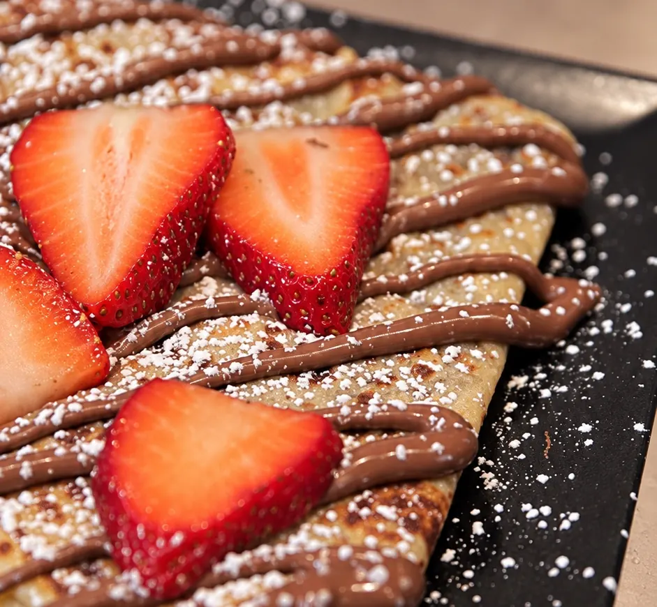 Crêpe con crema alla nocciola, fragole e zucchero a velo